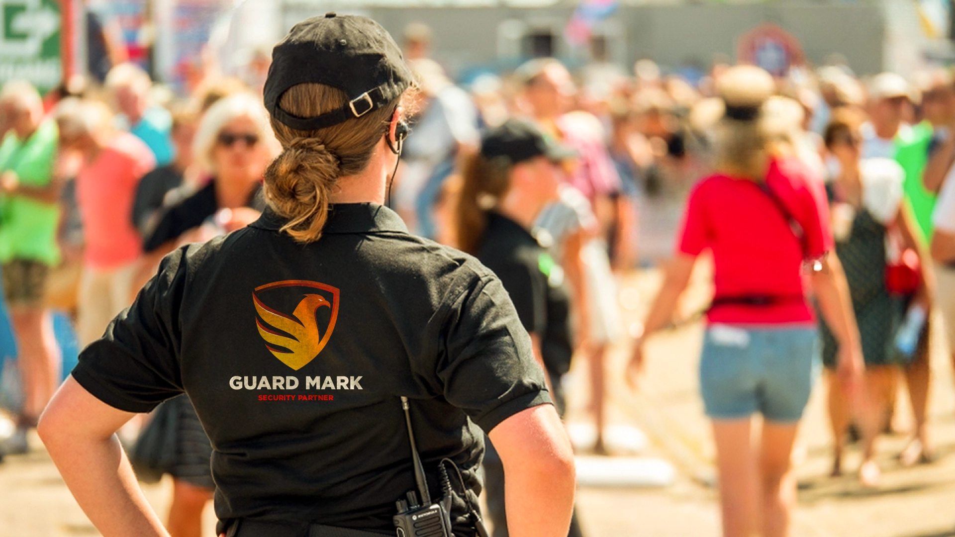 Female UK event security guard in Guard Mark uniform ensures safety at sporting and music festivals.